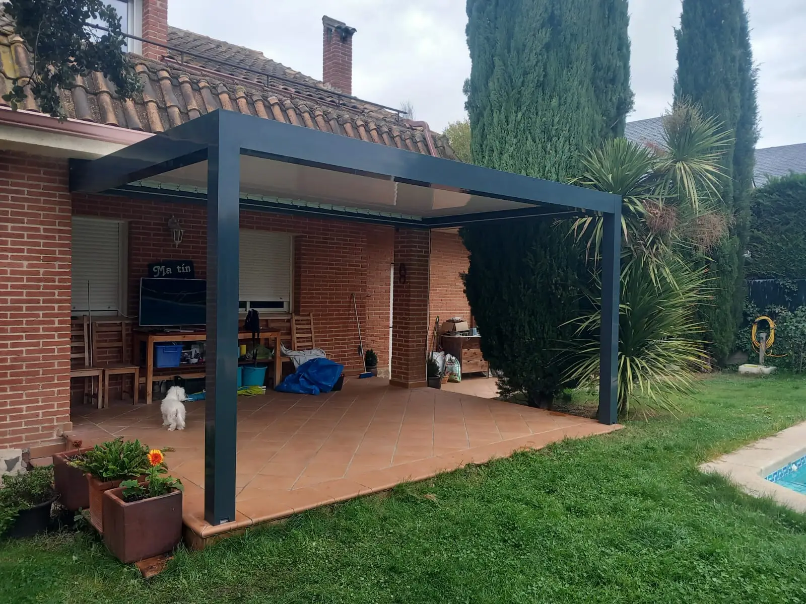 Pérgola bioclimática negra junto a piscina en jardín de Cádiz - Proyecto real Cerramientos Monper