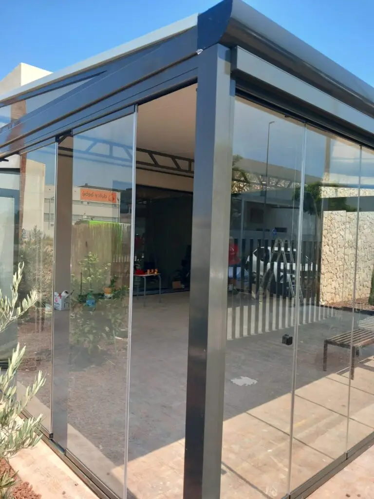 Pérgola bioclimática con cerramientos de cristal correderos para porche en Cádiz