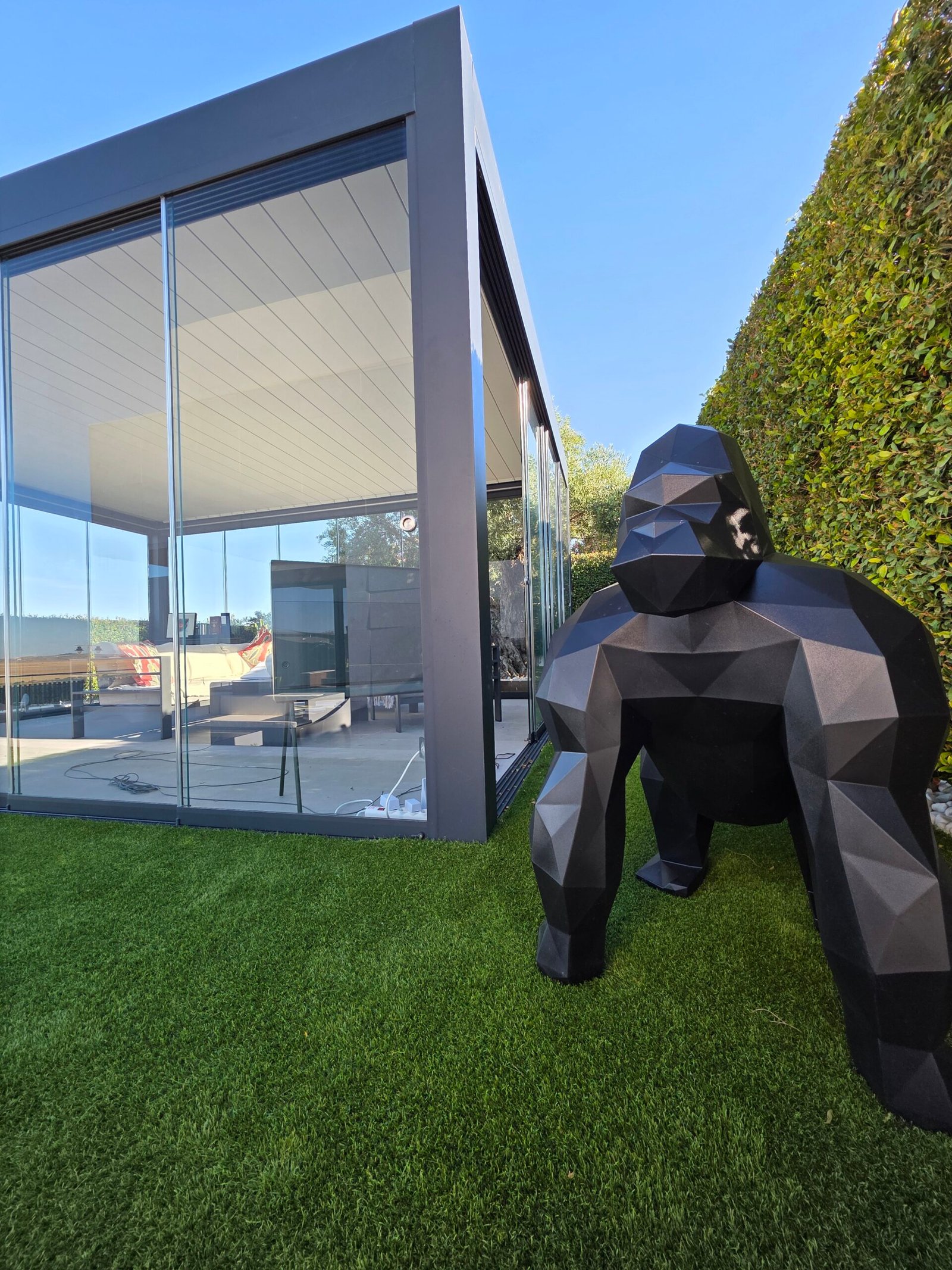 Pérgola bioclimática con correderas ZOE junto a olivo en jardín de Sanlúcar de Barrameda