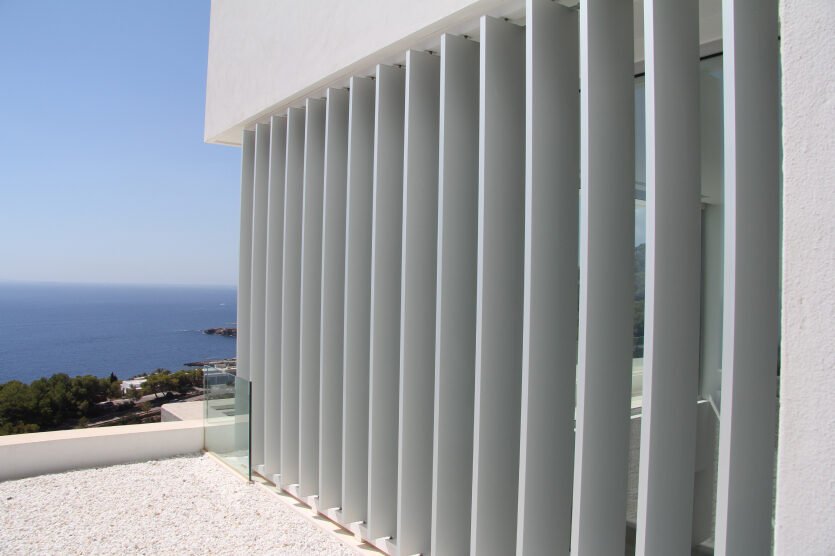 Celosía de lamas verticales de aluminio de Durmi en una fachada frente al mar