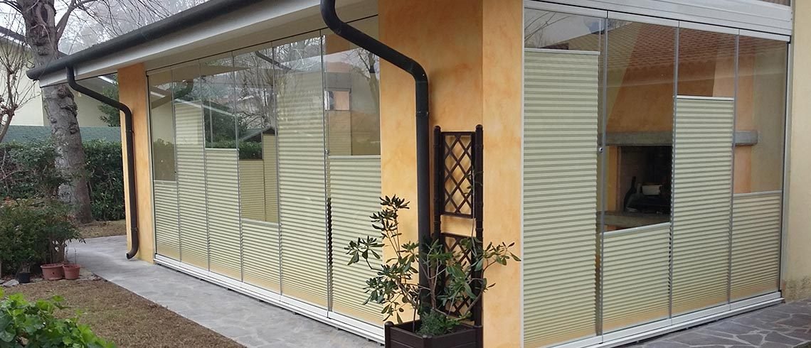 Cerramiento de cristal con cortinas plisadas en una terraza