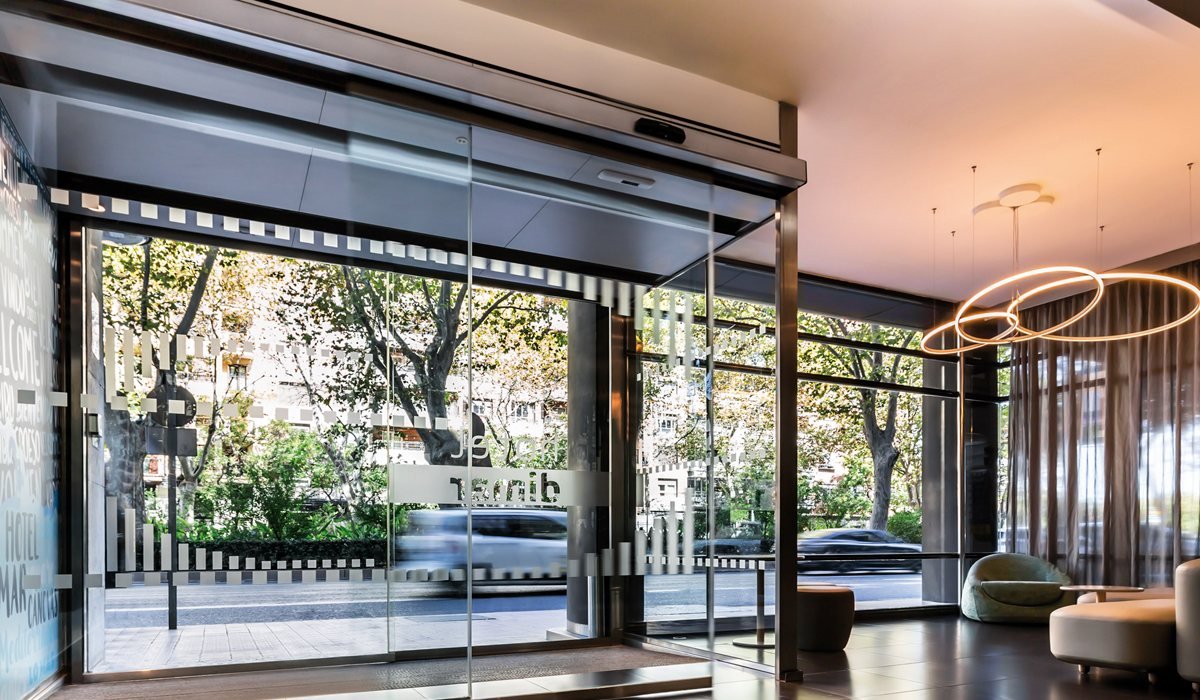 Puerta automática de cristal corredera de Saxun en la entrada de un local